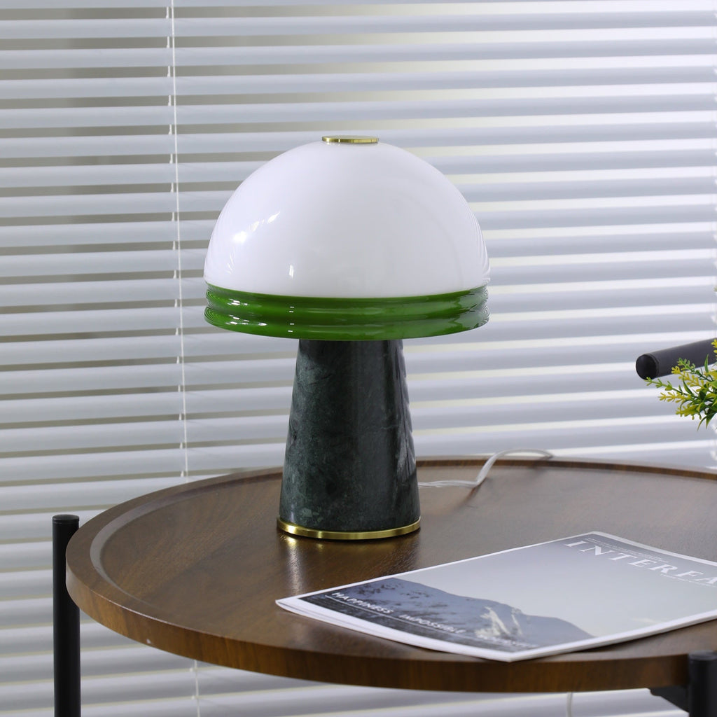 Wide shot of the Clérachic dome lamp showing its full green marble base and brass ring on the round table.
