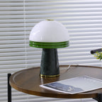 Wide shot of the Clérachic dome lamp showing its full green marble base and brass ring on the round table.