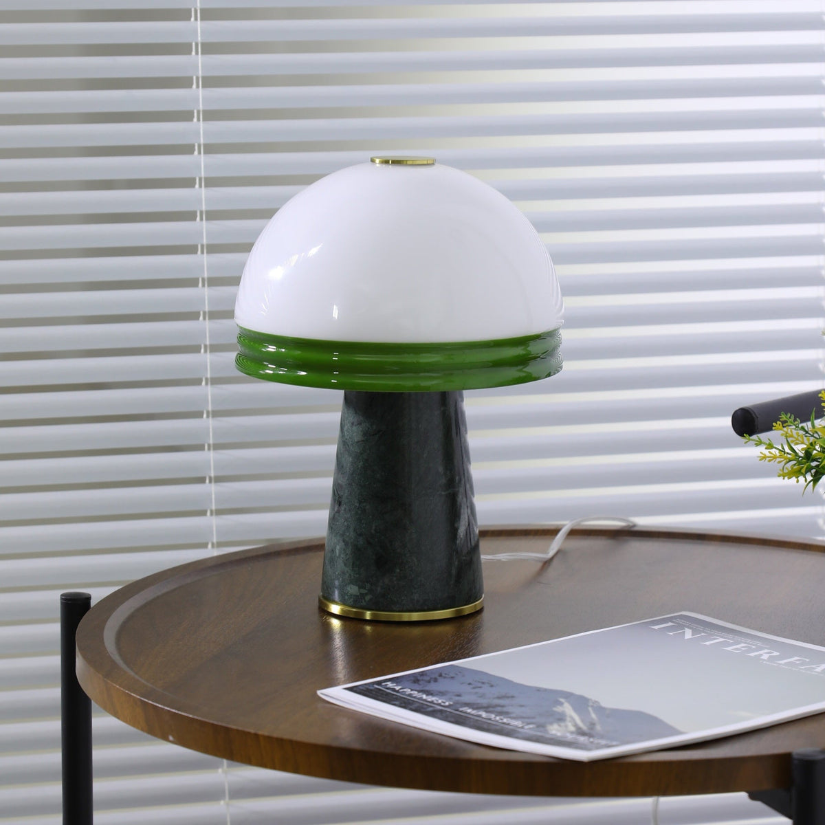 Wide shot of the Clérachic dome lamp showing its full green marble base and brass ring on the round table.