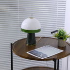 Zoomed further out, the lit Clérachic dome lamp sits above a faintly visible lower shelf on the round table.