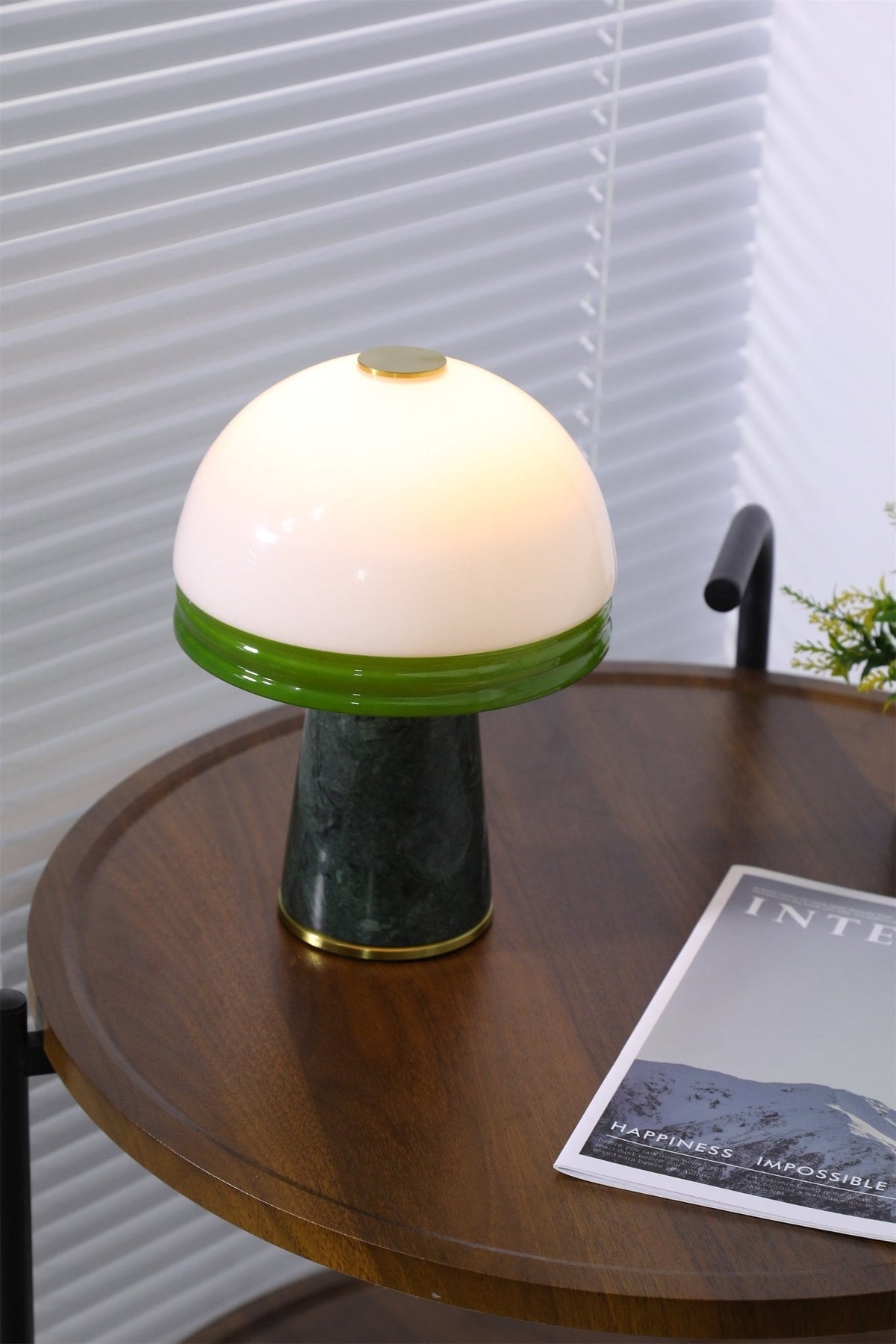 A close, cropped view of the Clérachic table lamp's white dome and green rim on the round tabletop.