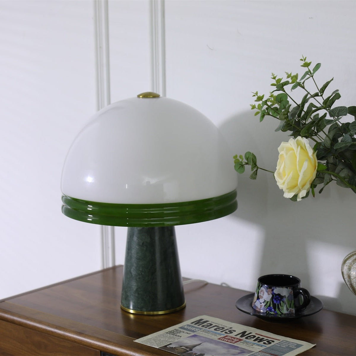 Close crop of the unlit Clérachic dome table lamp, its white glass dome and green rim filling most of the frame.
