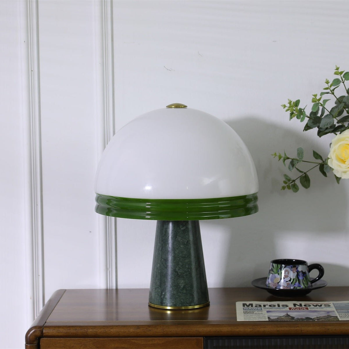 Seen from a standard three-quarter view, the unlit Clérachic dome table lamp sits on the wood cabinet beside a teacup.