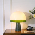 Warm light spills across the panelled wall behind the Clérachic dome table lamp, lit on the wood cabinet.
