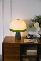 Clérachic dome table lamp lit beside a clear glass vase of white flowers, with no newspaper in this crop.