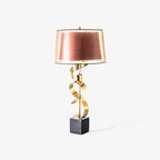 Clérachic table lamp with a twisted gold spiral stem and black marble base, shown on a plain white studio background.