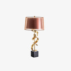Clérachic table lamp shown full-length on a cream studio background, its drum shade rendered in a rosy copper tone.