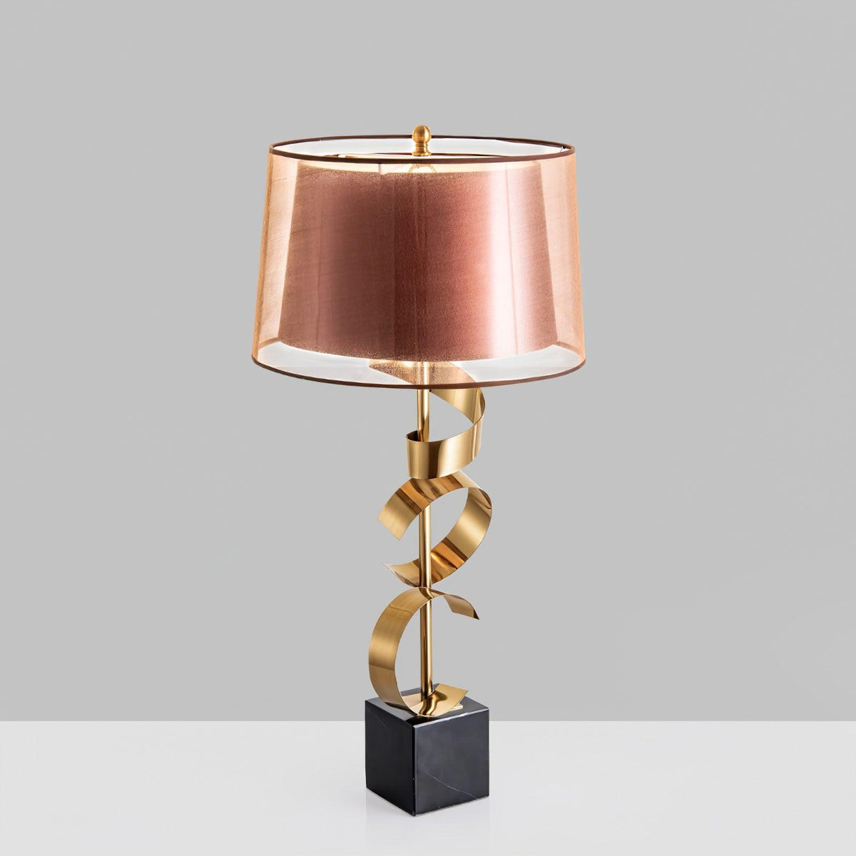 Clérachic gold spiral table lamp standing on a plain light-grey background, showing the full stem and marble base.