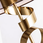 Macro detail of the Clérachic lamp's gold ribbon spiral shown alone against a white background, its curves fully exposed.