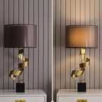 Two Clérachic gold spiral table lamps side by side on matching white nightstands, each with a differently toned drum shade.
