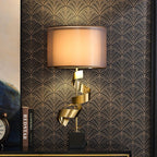 Clérachic gold spiral table lamp on a black shelf against art-deco wallpaper, standing beside a vintage clock and books.