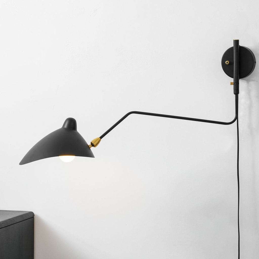 Adjustable wall sconce angled over a console table