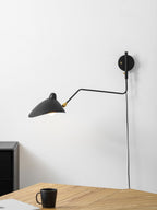 Swing-arm wall sconce mounted beside a doorway