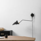 Wall sconce shade rotated to cast light downward on a desk