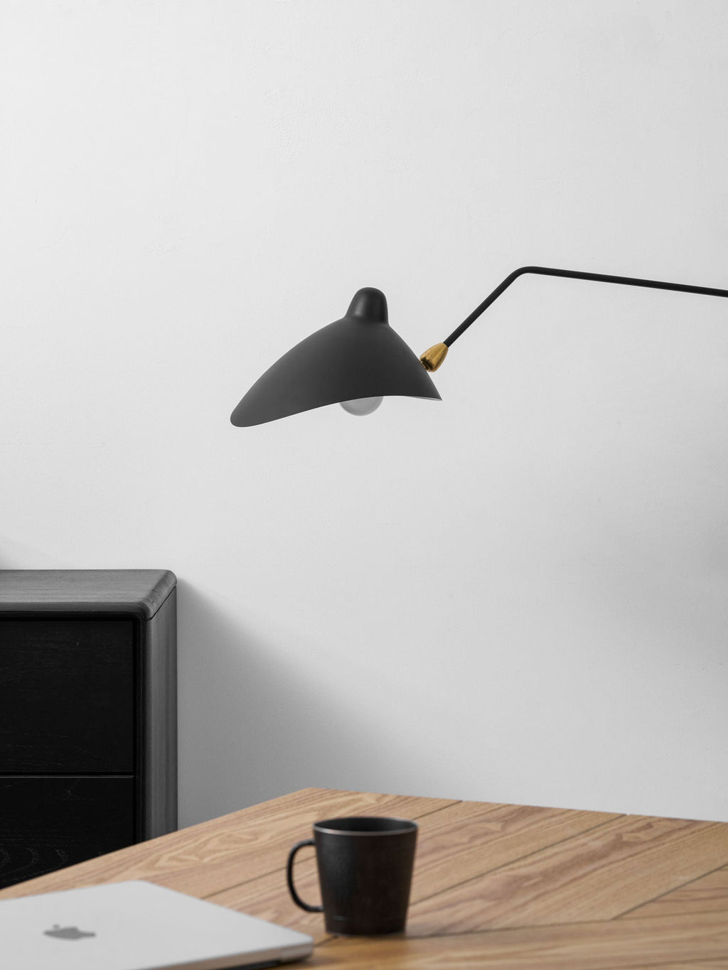 One-arm wall sconce shown in a minimal styled interior