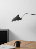 One-arm wall sconce shown in a minimal styled interior