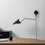 Wall sconce arm extended at full reach over a chair