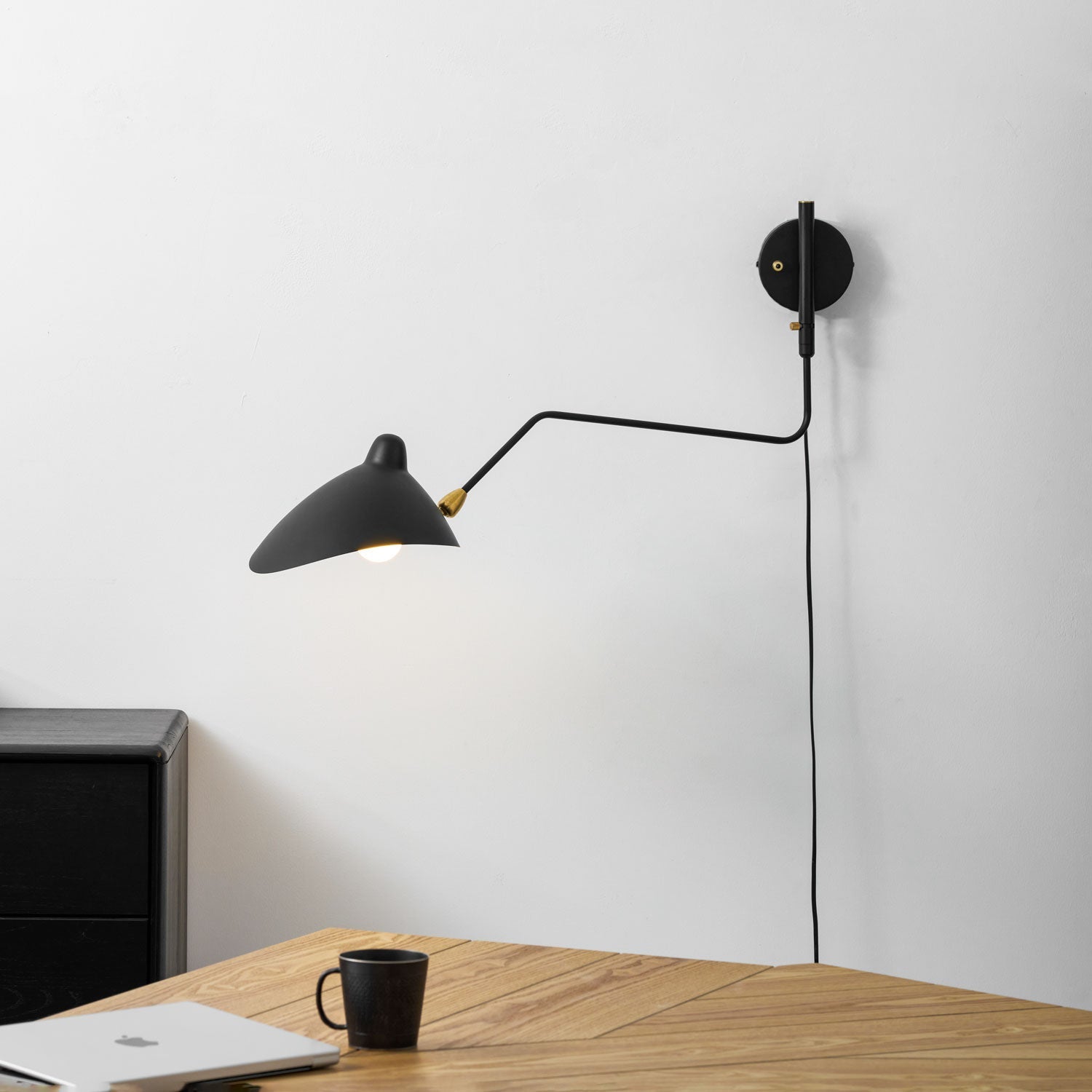 Adjustable wall sconce with shade tilted for ambient light