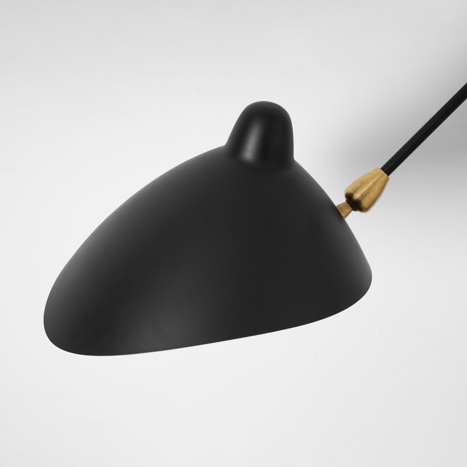 One-arm wall sconce angled to wash light across a wall