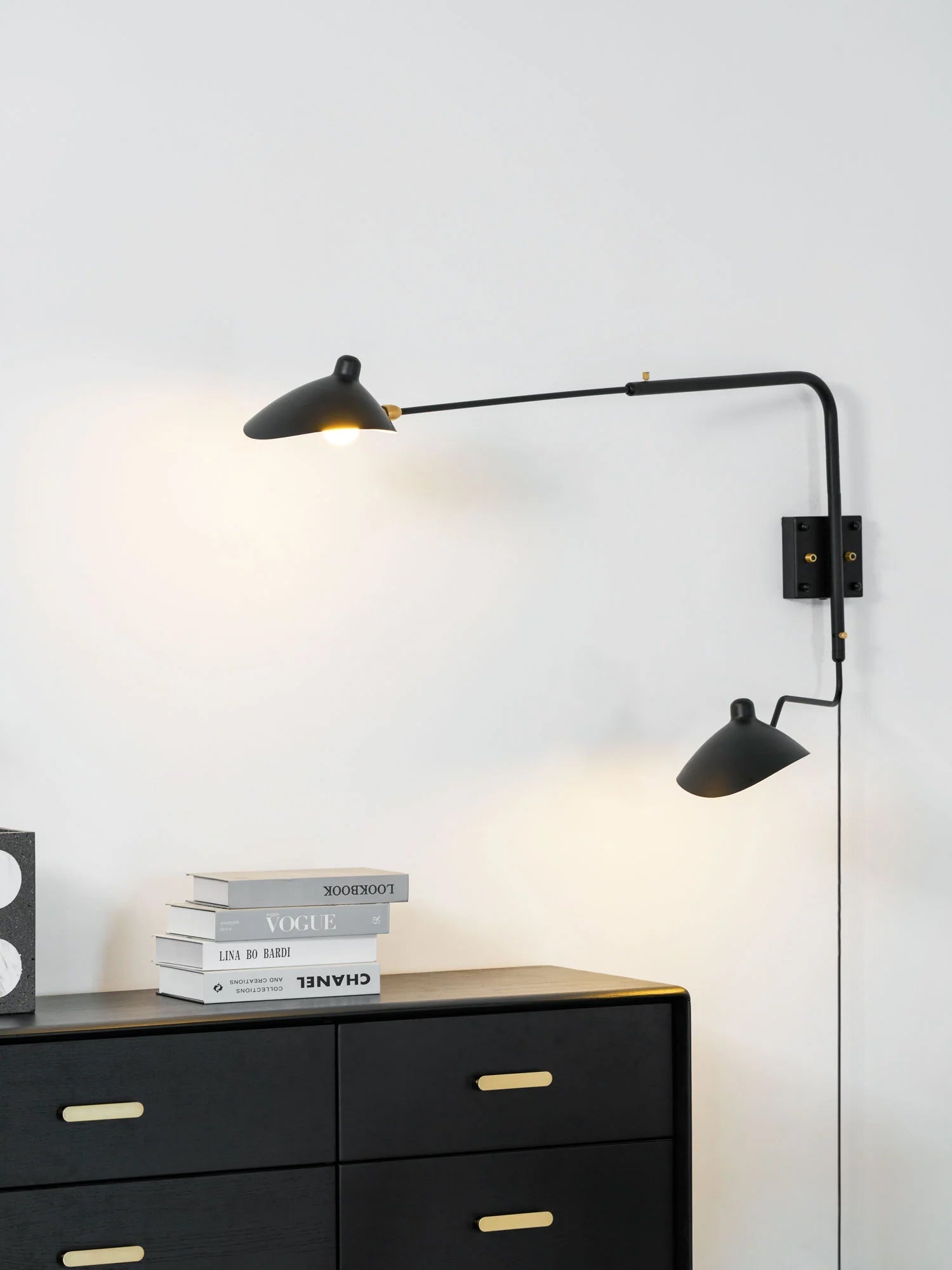 Single-arm wall sconce shown beside a bed for reading light
