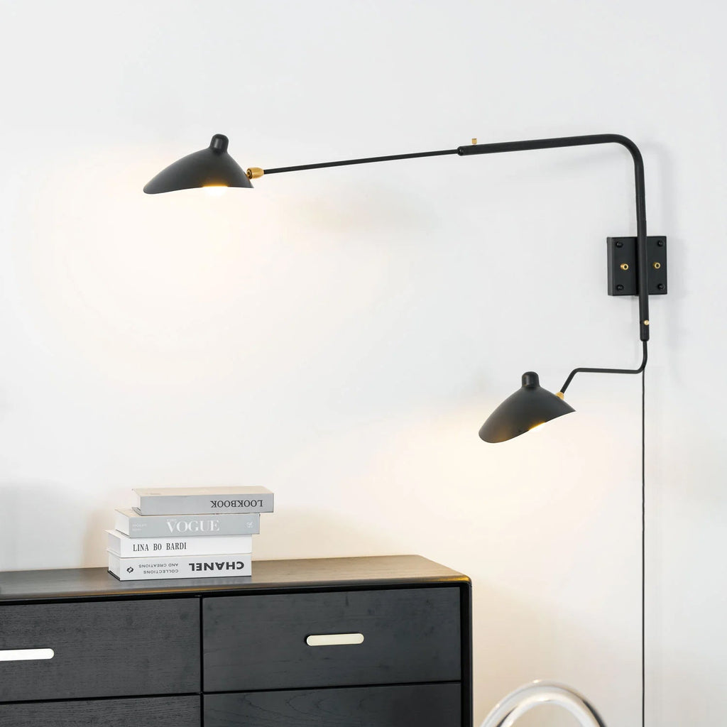 Swing-arm wall sconce extended over a small side table