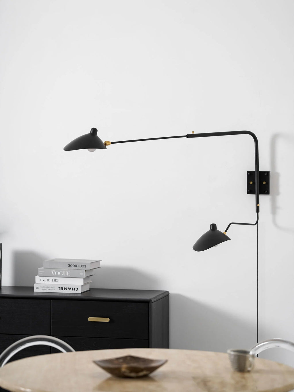 Wall sconce with rotating shade tilted upward toward the ceiling