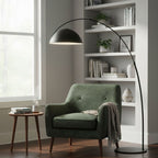 Verse arc floor lamp beside a bed in a soft-lit bedroom