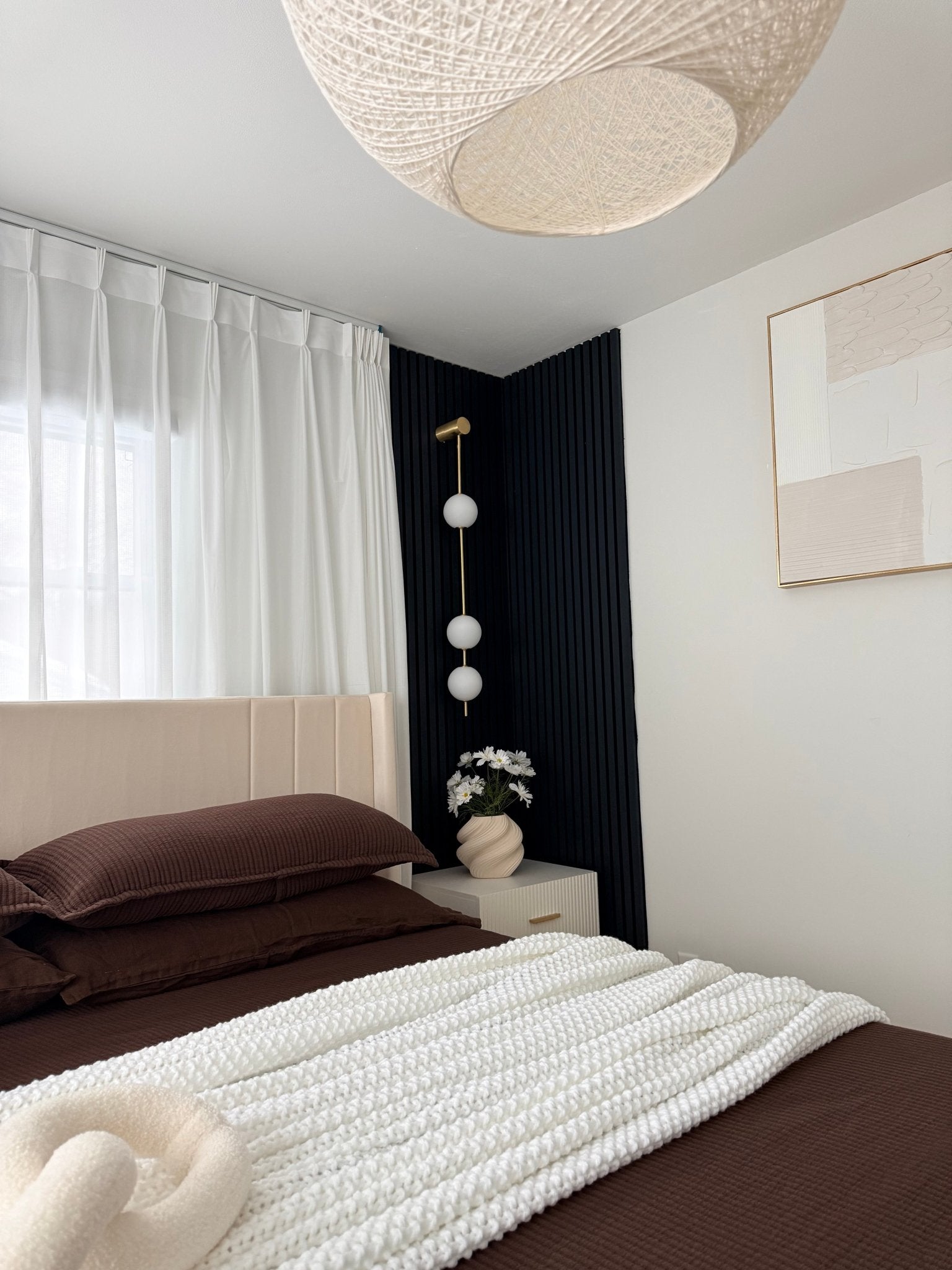 Brass vertical wall lamp with glowing globes in a quiet room
