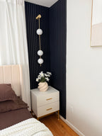 Vertical balls wall lamp glowing softly in a styled interior