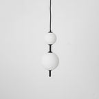 Glass globe pendant light with slim brass stem hanging