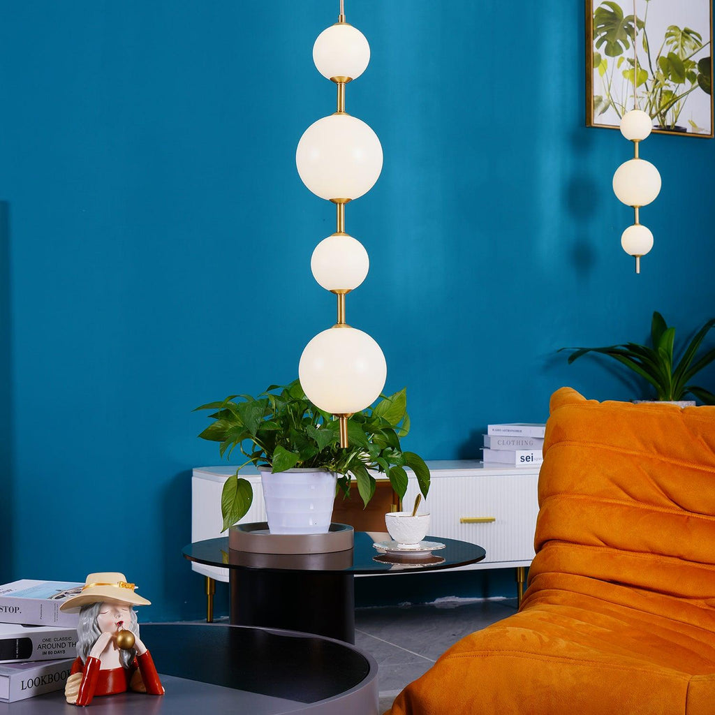 Vertical globe pendant light above a styled side table