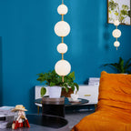 Vertical globe pendant light above a styled side table