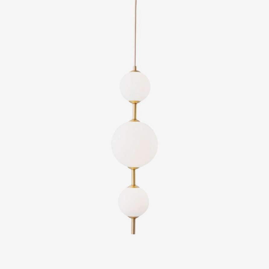 Vertical globe pendant light lit warmly in a kitchen