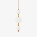 Vertical globe pendant light lit warmly in a kitchen