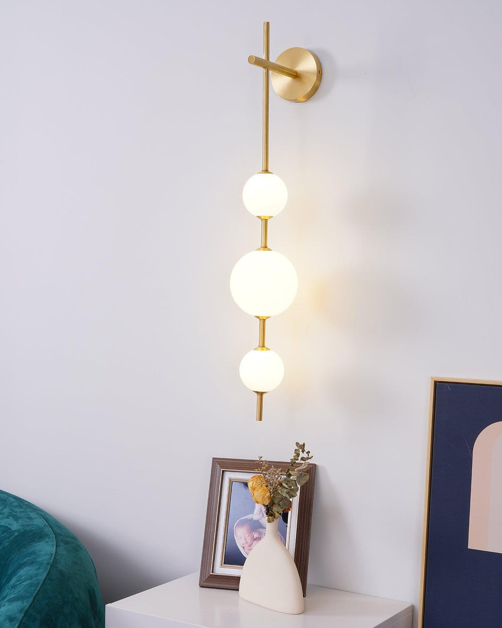 Stacked glass globe wall lamp glowing warmly in a living space