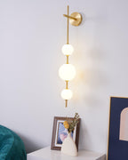 Stacked glass globe wall lamp glowing warmly in a living space