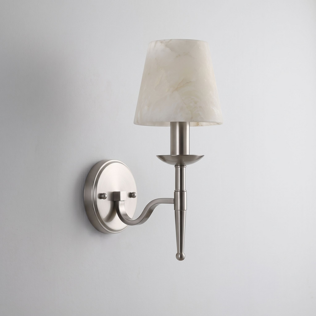 In brushed nickel, this Clérachic sconce curves its S-shaped arm up to a tapered alabaster cone shade.
