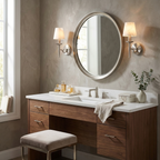 Nickel-finished, this pair of Clérachic sconces frames a round mirror above a vanity with a soap dispenser and towels.