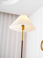 Close-up of the Clérachic floor lamp's lit shade and pull-chain switch near a doorway, a round mirror visible behind it.