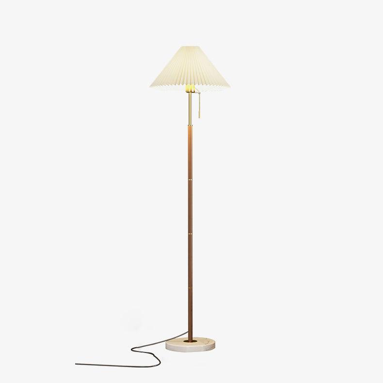 Clérachic floor lamp shown full-length on a plain white background, walnut stem and pleated shade lit softly.
