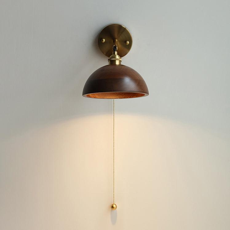 Walnut wood and brass wall sconce mounted on a wall