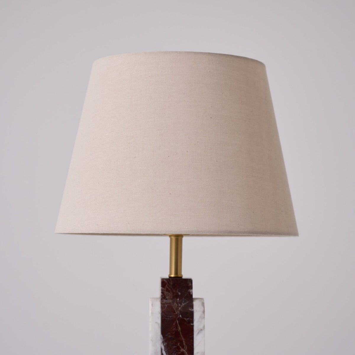 A close crop of the Clérachic table lamp's beige fabric shade, its tapered form filling most of the frame.