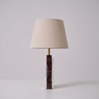 The Clérachic marble table lamp in profile on a studio background, its cord trailing to the floor beside the base.