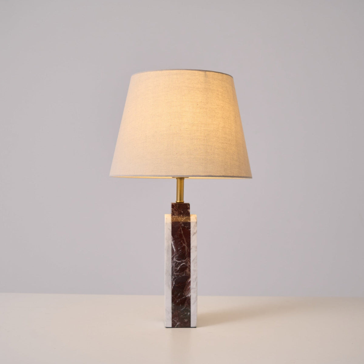 The Clérachic marble table lamp on a plain studio background, its dark veined column lit at a three-quarter angle.