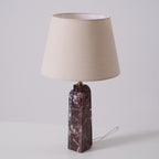 The Clérachic table lamp on a plain studio background, its cord visible trailing from the dark marble base.