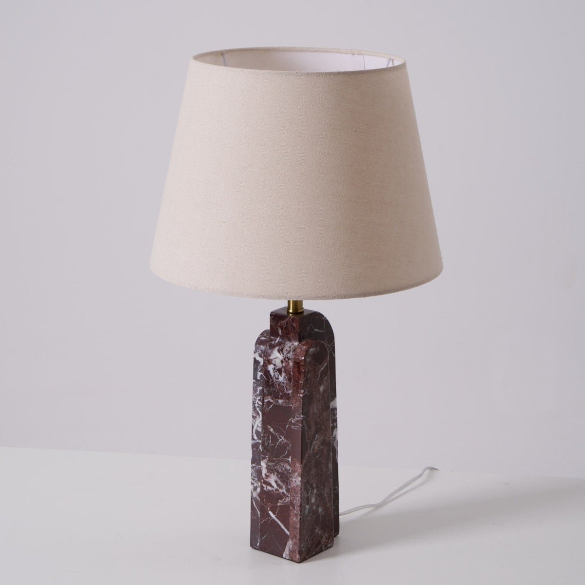 The Clérachic table lamp on a plain studio background, its cord visible trailing from the dark marble base.