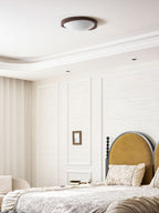 Round walnut ceiling light shown close up on white