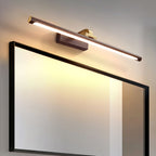 Close angle on this Clérachic wall light in walnut and brass, mounted above a black-framed mirror on a grey wall.
