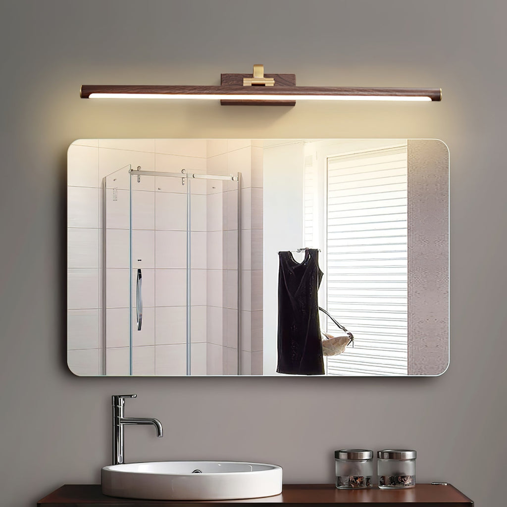 This Clérachic wall light in walnut and brass spans a wide bathroom mirror, with a black dress reflected in the door.
