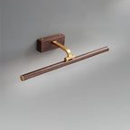 Close view of the walnut and brass pivot joint on this Clérachic wall light, unlit.